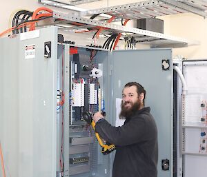 Expeditioner having fun pretending to use a battery operated angle grinder in an electrical switch board.