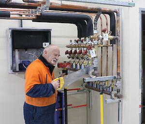 Expeditioner having fun pretending to cut metal copper pipes with a wood panel saw.