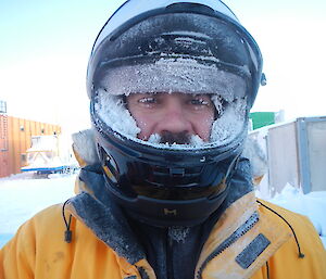 A close up of Adam with his helmet on and everything frozen, including his beard.