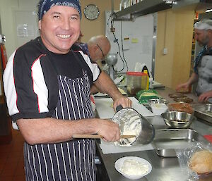 Danny cleaning out the mixing bowl with a wooden spoon.