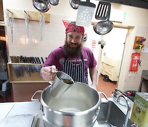 Adam adding a little olive oil to his dough in the large stainless steel mixing bowl.