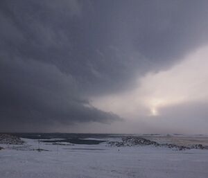 Looking out over the open water that was sea ice with a large dark storm cloud filling the sky.