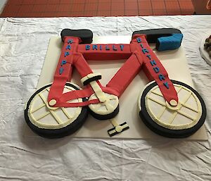 Photo of the brightly decorated birthday cake in the shape of a bike.