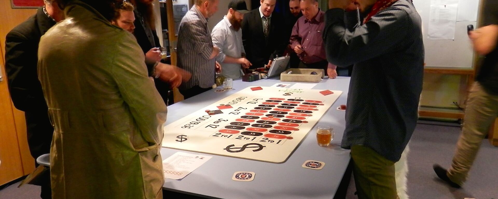 Roulette players standing around the makeshift roulette table.