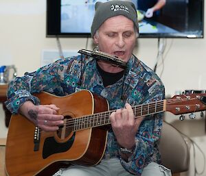 Jeff playing the guitar and harmonica.