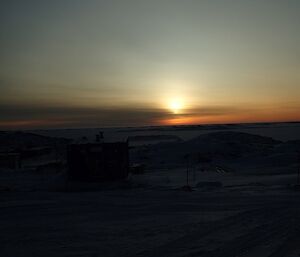 A large bright glow of light above the actual sun which is covered in cloud