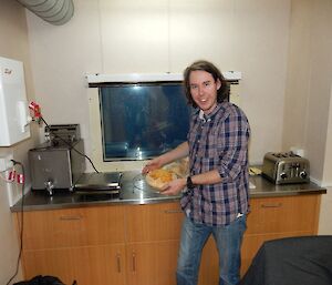 Steve showing off a loaf of bread he has just baked.