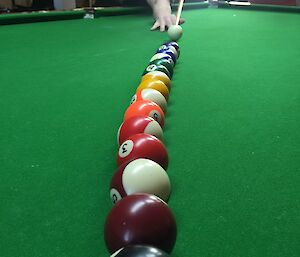 All the balls are lined up row, sorted by rainbow colour with Jimmy aiming to hit the white ball into them.