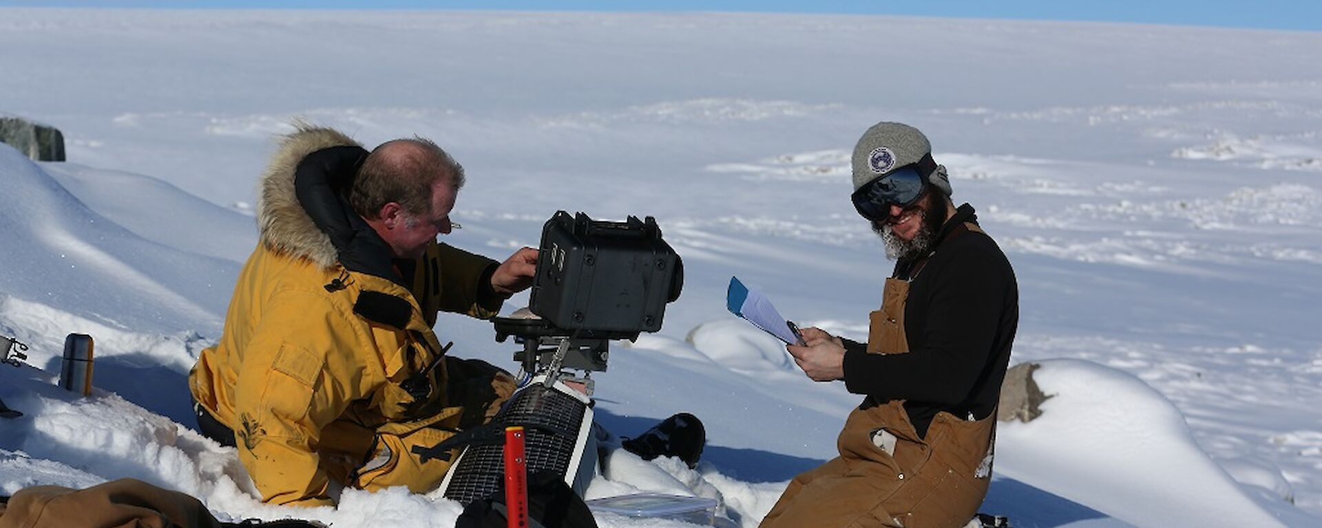 Andy and AJ sitting next to the camera, going through the maintenance check list.