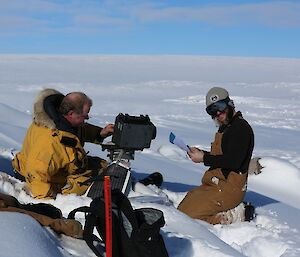 Andy and AJ sitting next to the camera, going through the maintenance check list.