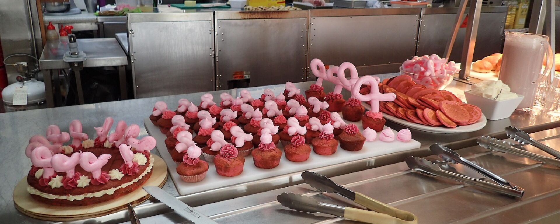 Pink cupcakes, pink sponge and pink pikelets each with a pink ribbon out of meringue ready for morning tea.
