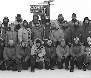 The 27 expeditioners in three rows in front of the Casey sign for the winter team black and white photo.