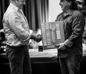 Station plaque with large wooden key is handed from outgoing to incoming station leader