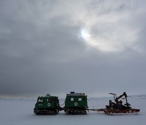 A Hägglunds pulling a trailer crosses the sea ice