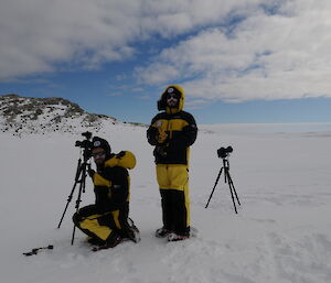 Two journalists stand by a movie camera in the Antarctic wilderness