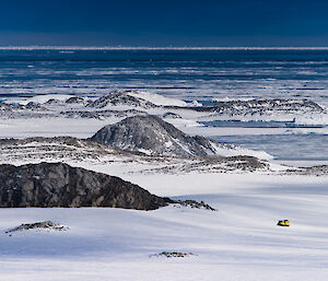 A Hägglund snow vehicle is dwarfed by the Antarctic scenery on the Mitchell Peninsula