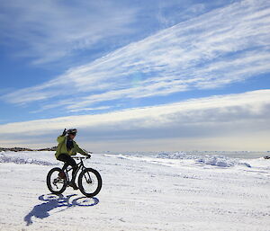 An expeditioner riding a bike on the ice.
