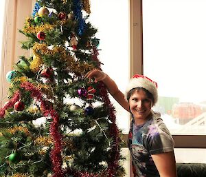 An expeditioner decorates the Station Xmas tree