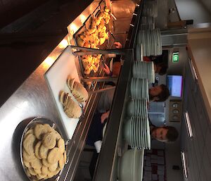 Expeditioners help themselves to some fresh bakery items in the mess room.