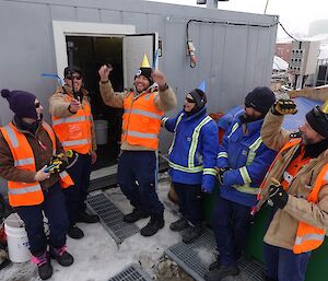 Expeditioners celebrate the opening of the water treatment container