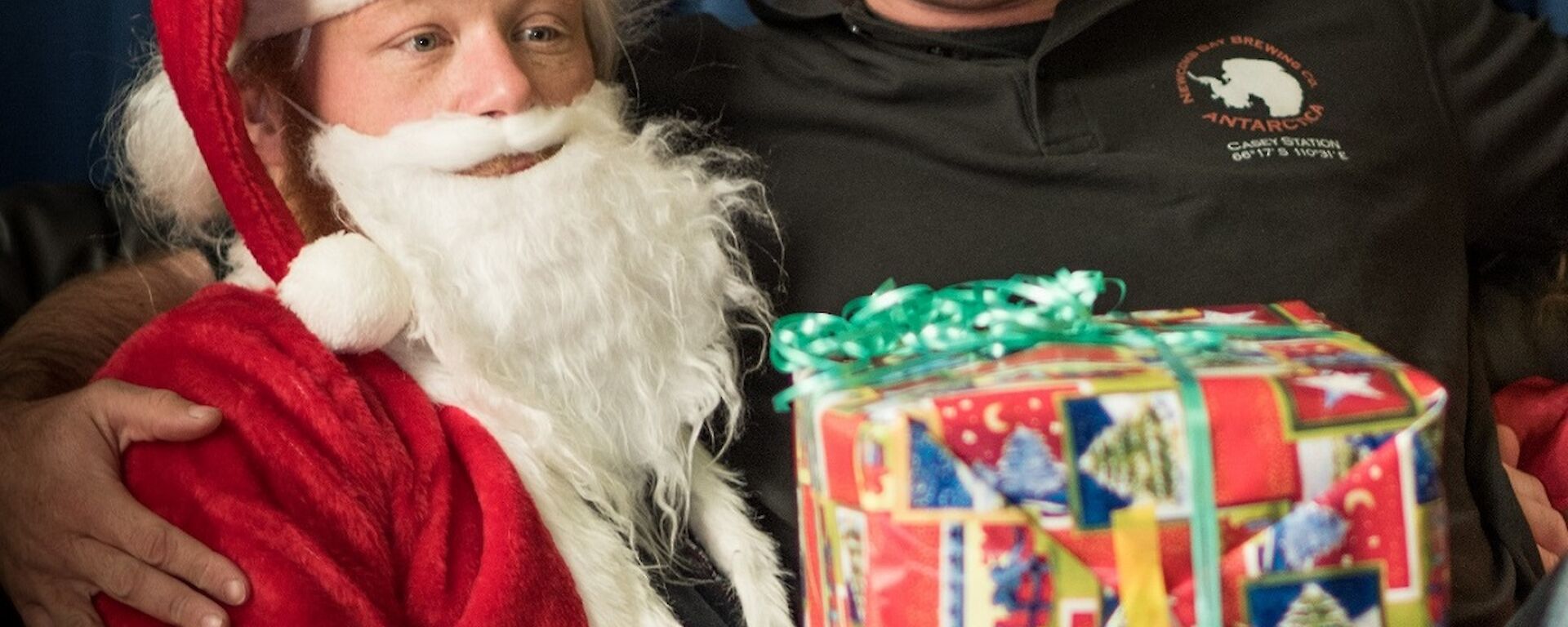 An expeditioner recives a Christmas gift from Santa