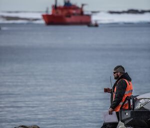 An expeditioner awaits the arrival of the barge at Casey wharf during resupply