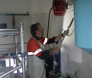 A tradesman paints inisde the Casey balloon shed