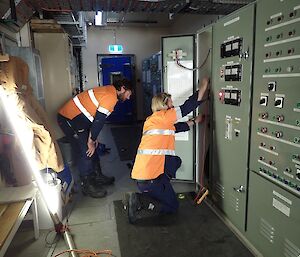 Two electricians inspector a large power board in the Casey Emergency Powerhouse