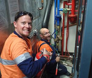 A plumber Charlie works on piping in the Casey science building