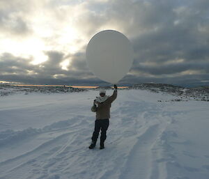 A Casey weather observer releases a weather balloon
