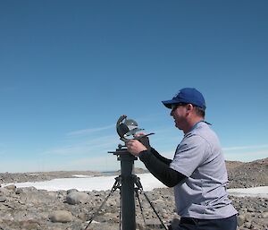 A weather observer checks the sunshine recorder