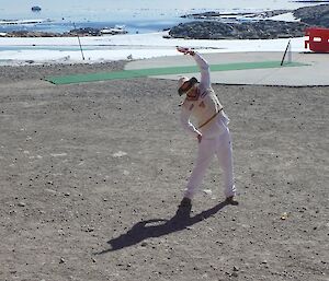 An expeditioner stretches before bowling in the cricket match