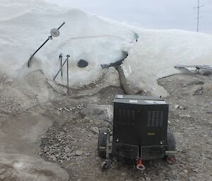 A machine pumping air into a snowbank to help find site services pipes underneath