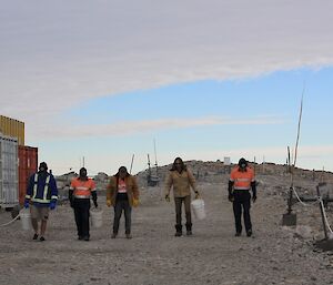 Expeditioners walk along looking for rubbish to pick up