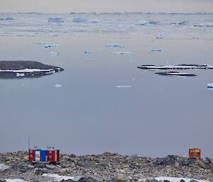 A view of Jack’s donga hut with water in front and rocks behind