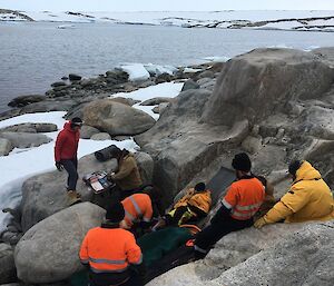 Expeditioners provide first aid to the patient during the SAR exercise