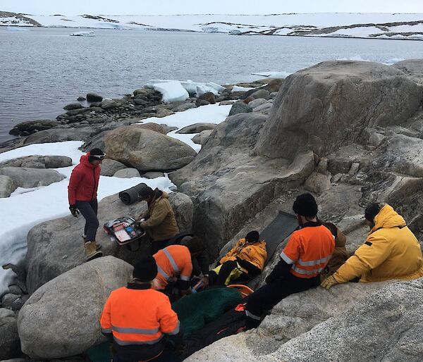 Expeditioners provide first aid to the patient during the SAR exercise