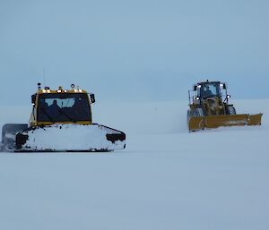 A snow groomer and dozer work on the Wilkins runway