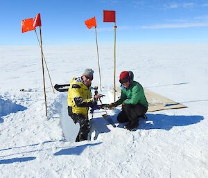 Two expeditioners enjoy a cheese platter out on the ice