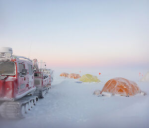 Tents pitched on the ice with a misty sunrise