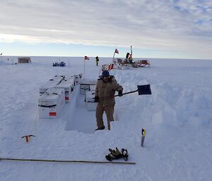 An expeditioner digs a sample trench