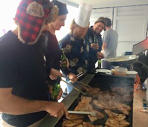 Expeditioners cook a BBQ at Casey station