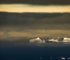 Icebergs shadowed by a dark sky