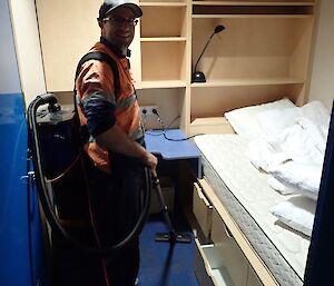 Expeditioner in bedroom with vacuum cleaner