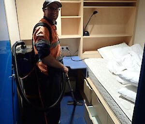 Expeditioner in bedroom with vacuum cleaner