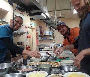 Three expeditioners making pizza in the kitchen