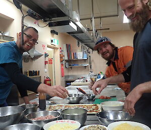Three expeditioners making pizza in the kitchen