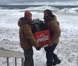 Two expeditioners carrying a coke machine