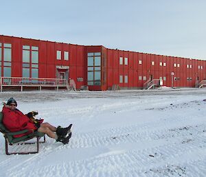 Linc in an arm chair with Red Shed in background