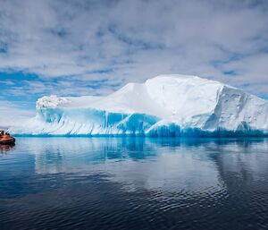 Iceberg with boat in foreground